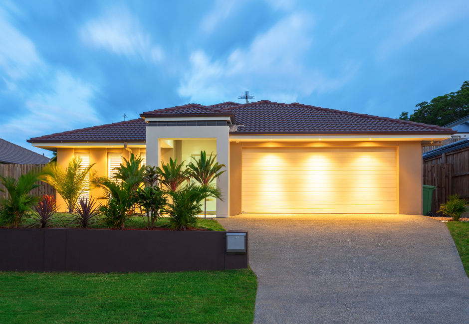 modern house with lights on and beautiful garden