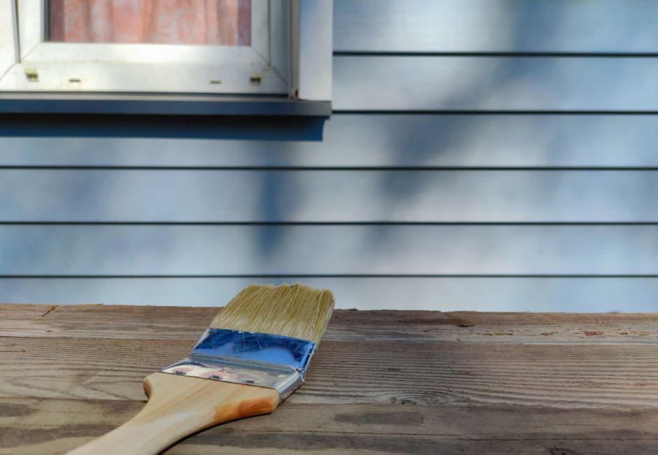 blue weatherboard house with paintbrush